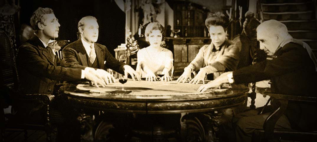 Photo from old movie of people holding a séance