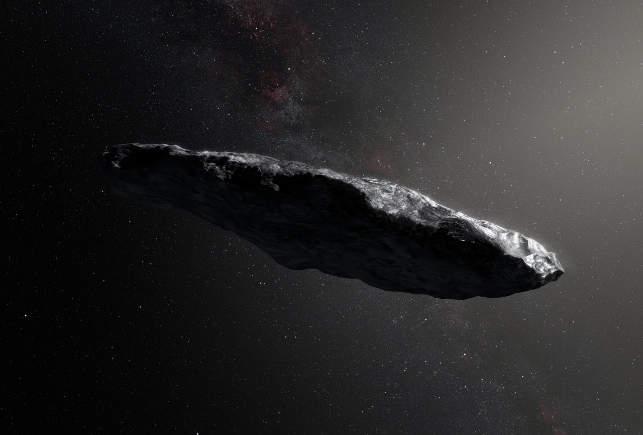Artist’s impression of the interstellar asteroid, Oumuamua, showing a large, cigar-shaped rock against a star field